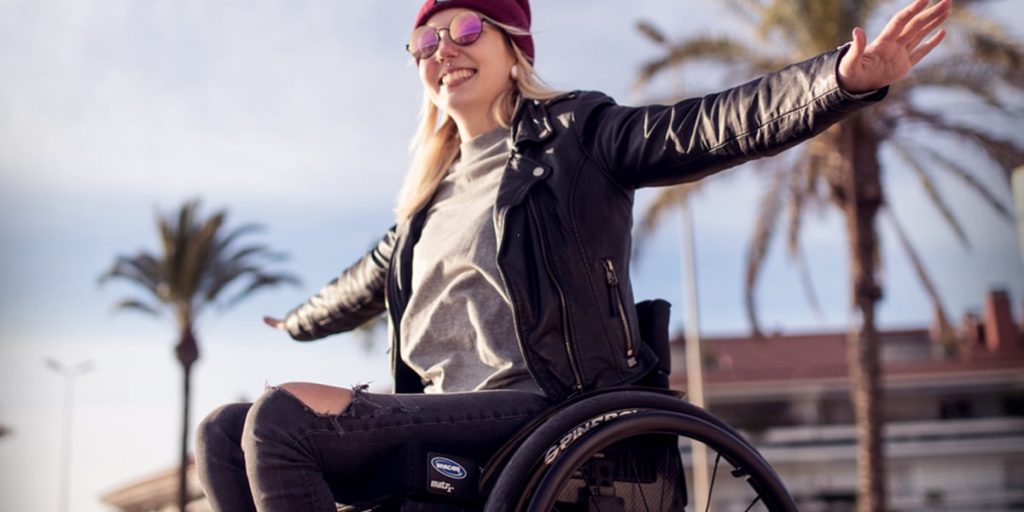 Image shows happy independent woman in power assisted chair